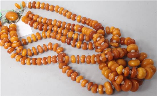 A triple strand amber bead necklace with amber set clasp and paste spacers, 22in.